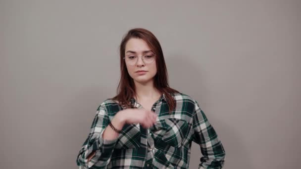 Szürke háttér stílusos nő szemüvegben meglepett, mutatja négy ujját — Stock videók