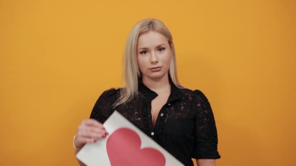 Meisje een geïrriteerde boze vrouw schreeuwt nerveus vasthouden stuk papier rood hart — Stockvideo