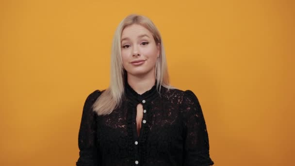 Chica en vestido negro sobre fondo amarillo mujer con estilo muestra su dedo índice — Vídeos de Stock