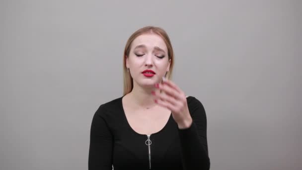 Junge blonde Frau in schwarzer Jacke hält verzweifelt die Hand vor den Kopf — Stockvideo