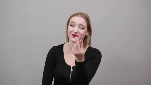Rubia chica en negro chaqueta feliz mujer muestra pequeño tamaño con sus dedos — Vídeos de Stock