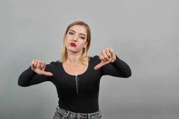 Girl in black jacket dissenting woman returns thumbs down, shows protest dissent — Stockfoto