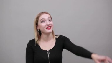 Young blonde girl in black jacket happy smiling woman shows size with fingers