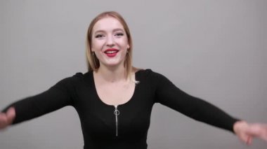 Young blonde girl in black jacket emotional woman screams, shows emotions