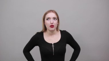 girl in black jacket shocked woman reacts to surprise, holding head with hands