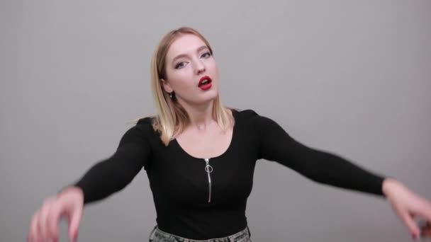 Young blonde girl in black jacket stylish woman shakes her fists back and forth — Stockvideo