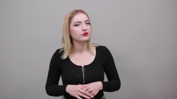 Chica en chaqueta secreta mujer hace gesto de silencio, sostiene índice dedo a cara — Vídeo de stock