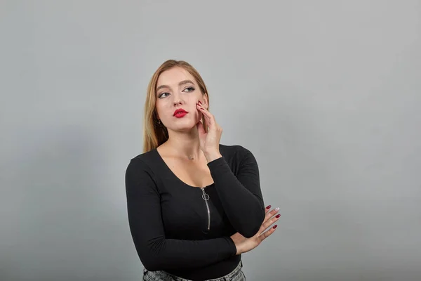 Young blonde girl in black jacket stylish woman touches her hand to face — Stockfoto