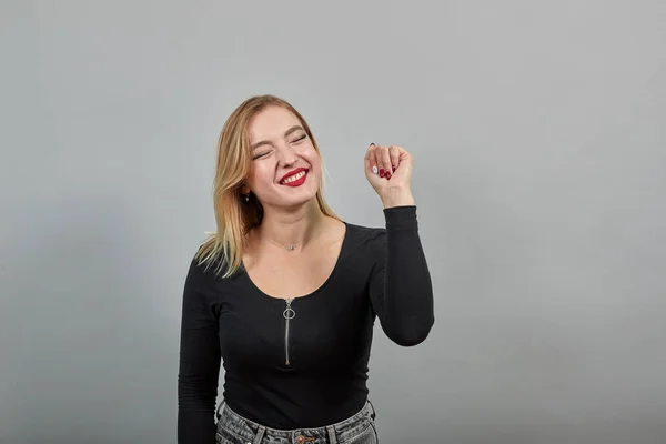 Young blonde girl in black jacket happy woman holds up her hand — Φωτογραφία Αρχείου