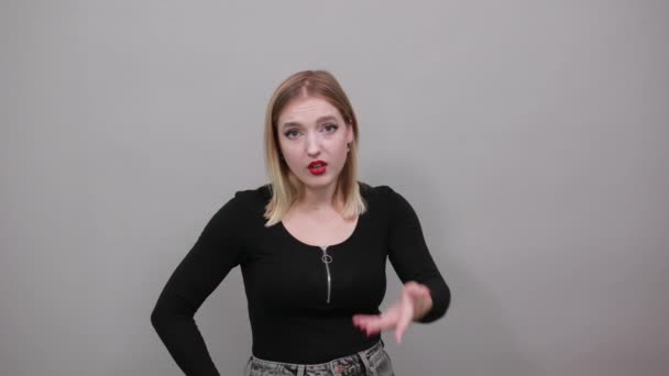 Молодая блондинка в черной куртке инакомыслия против женщины, держит руки скрещенными — стоковое видео