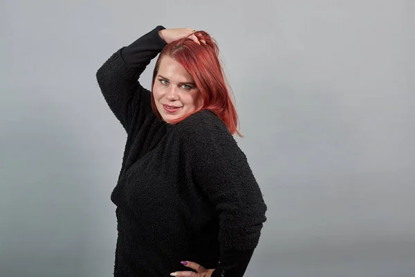 Redhead girl in black sweater fat woman plays with her hair, adjusts hairstyle — Stock Fotó