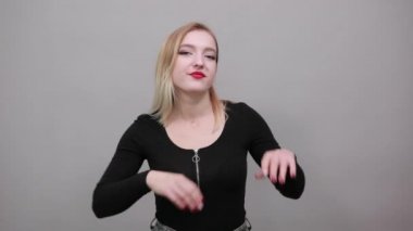 Young blonde girl in black jacket happy woman touches her face with hands