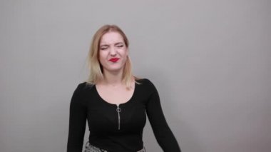 girl in jacket expressive woman screams and puts two fingers to head like gun