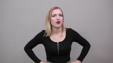 Young blonde girl in black jacket frightened woman gestures with her hands