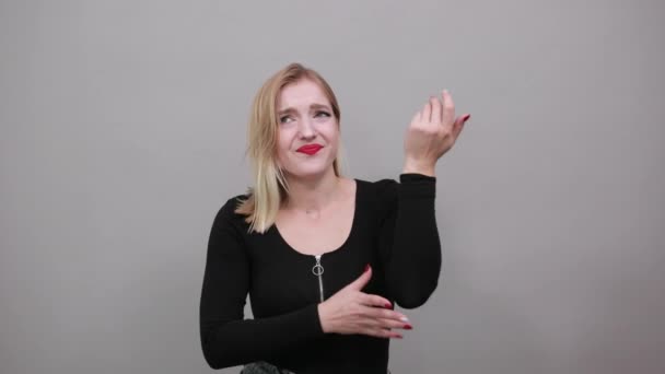Девушка в черной куртке несчастная женщина просит прощения, жесты руками — стоковое видео