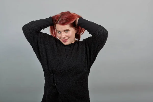 Fat lady in black sweater rear woman posing for camera holding hair with hands — Stock Fotó