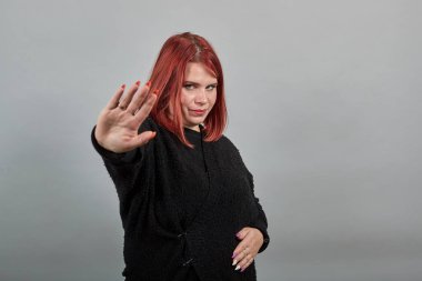 fat lady in sweater angry woman protests, shows palm hand as stop sign, enough