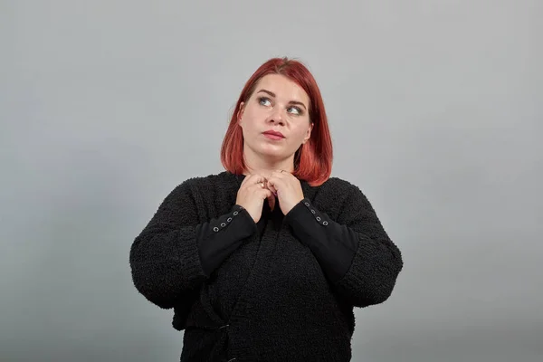 redhead fat lady in black sweater stylish woman sticks a button in buttonhole