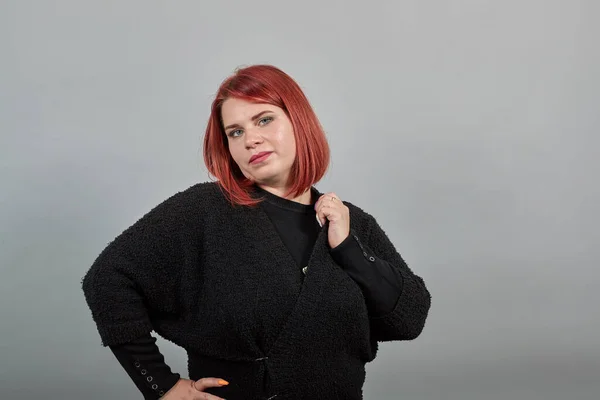 Young redhead fat lady in black sweater stylish woman posing for the camera