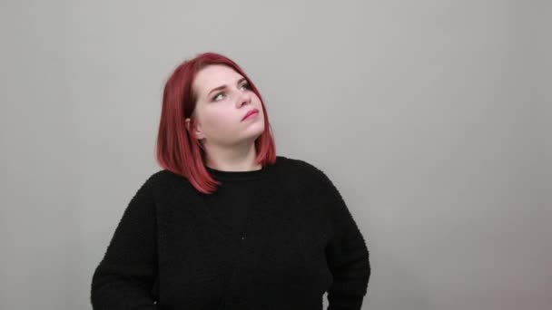 Young redhead fat lady in black sweater woman thinks, touches chin with hand — Stock Video