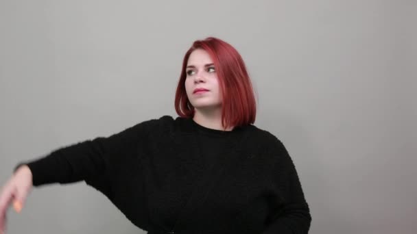 Young redhead fat lady stylish woman raised hand up and holds it behind head — Stockvideo