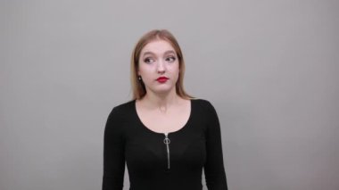 girl in black jacket shocked woman reacts to surprise, holding head with hands