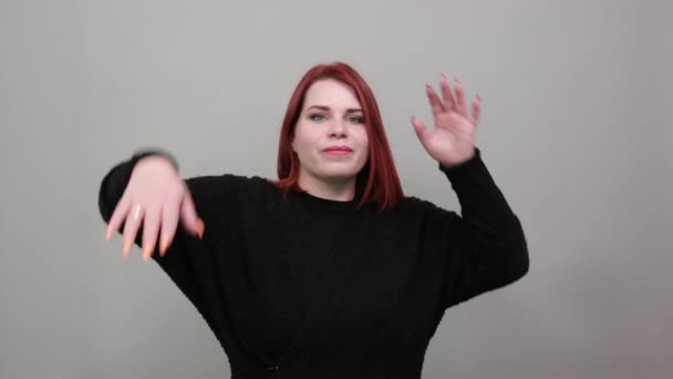 Young redhead fat lady in black sweater funny woman holds hands above head — Stockvideo