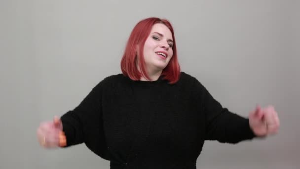 Young redhead fat lady in black sweater happy woman rejoices, raises hands up — Stock Video