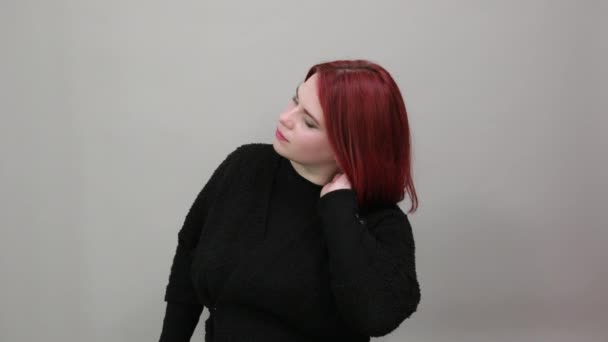 Молодая рыжая толстая леди в черном свитере умная женщина думает, держит руку над головой — стоковое видео