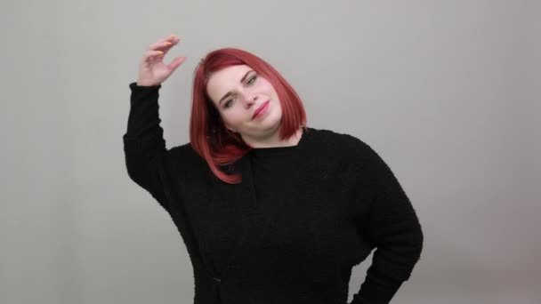 Молодая рыжая толстая леди в черном свитере соблазнительная женщина касается волос рукой — стоковое видео