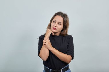 Siyah tişörtlü genç esmer bayan. Hoş, güzel bir kadın. Eline hafifçe dokunuyor.