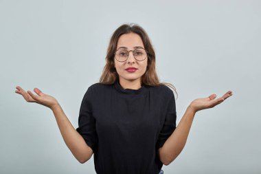 Kafası karışmış gözlüklü kız ellerini açık bıraktı.