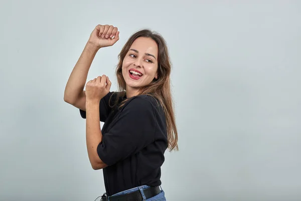 Menina feliz sorri e dança com as mãos — Fotografia de Stock