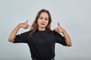 Kız gururla bakar ve işaret parmaklarıyla kendini gösterir.