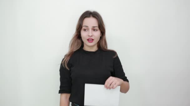 Not Happy Girl Complains, Shows Direction With Thumb. Holds An Empty White Sheet — Stock Video