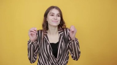 Mutlu kız gülümser ve elleriyle hareket eder, yönü işaret parmaklarıyla gösterir