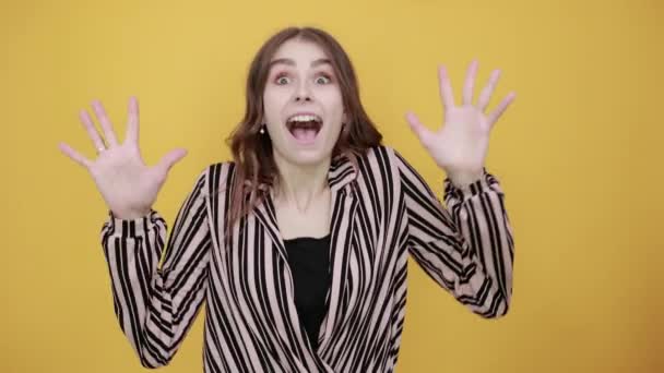 Garota sorridente ri e reage expressivamente emocionalmente, espalhando seus braços largos — Vídeo de Stock
