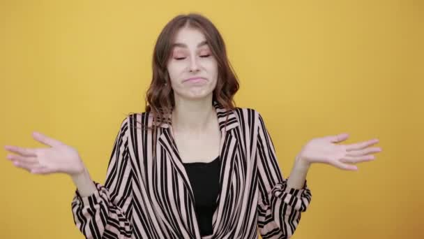 Удивлённая девушка не знает, как реагировать на ситуацию, широко раскидывая руки — стоковое видео