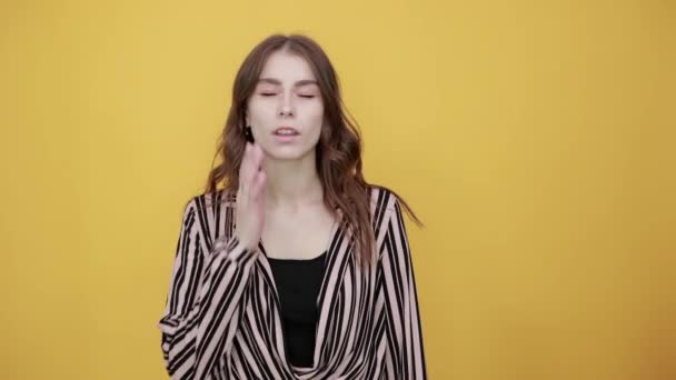 Уставшая девушка страдает от зубной боли, держа руку на щеке — стоковое видео