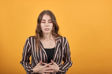 Kız bükülmüş, karın ya da karın ağrısından suratını buruşturmuş, ellerini tutarak yaralanıyor.