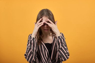 Üzgün kız elleriyle yüzünü kapadı.