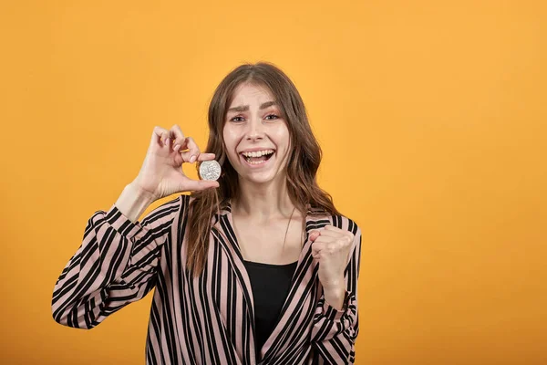 Chica feliz sonriendo y sosteniendo moneda Bitcoin — Foto de Stock