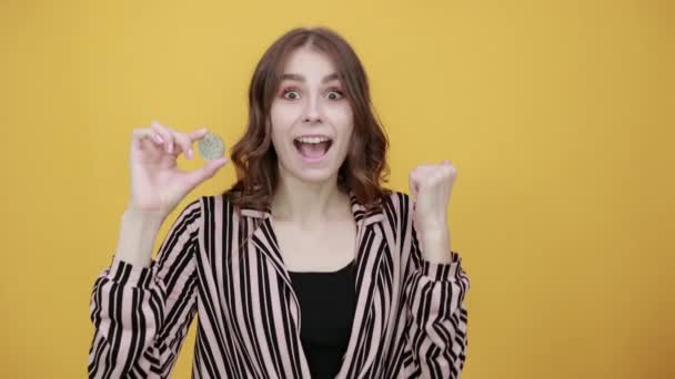 Chica feliz sonriendo y sosteniendo moneda Bitcoin — Vídeos de Stock