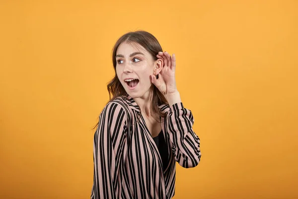 Gericht meisje houdt haar hand aan oor en luistert. Het concept van geheimhouding, roddels — Stockfoto