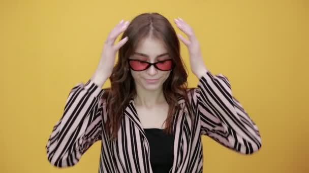 Αναστατωμένη κοπέλα με γυαλιά ηλίου κρατώντας τα χέρια της στο μέτωπο από τον πόνο στο κεφάλι, πονοκέφαλος — Αρχείο Βίντεο