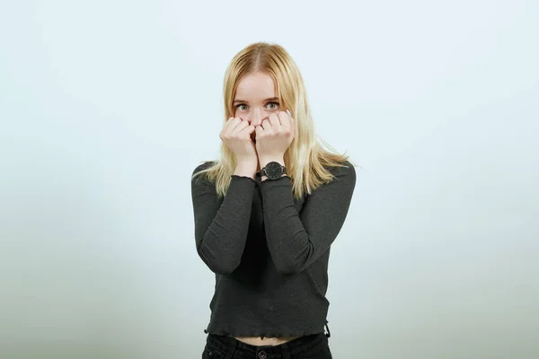 Scared Girl sostiene sus manos apretadas en los puños cerca de la cara. Miedo, incertidumbre — Foto de Stock