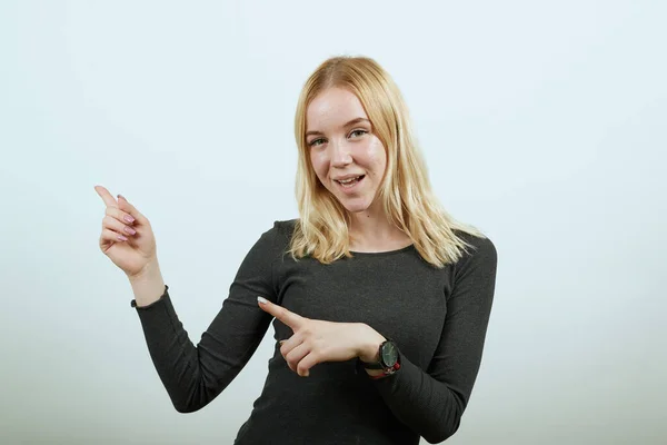 Glückliches attraktives Mädchen lächelt Zeigefinger auf die Person in der Nähe — Stockfoto