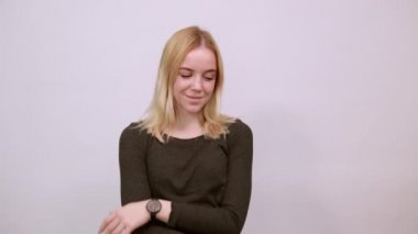 Kendine güveni olan şık bir kız, elini göğsüne dayar..