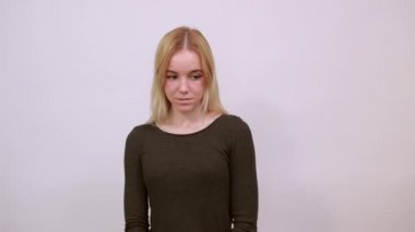 Mutlu Çekici Kız gülümsüyor, elleriyle yüzüne dokunuyor.