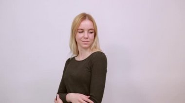 Mutlu Çekici Kız gülümsüyor, ellerini göğsünde çapraz tutuyor..